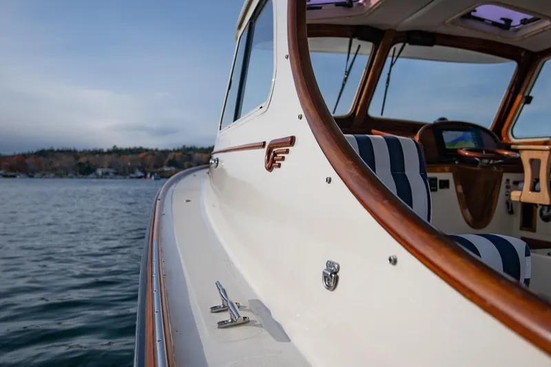 Slide: The Image of 2001 Hinckley Picnic Boat Classic with striped seating, cruising on calm waters. - 22