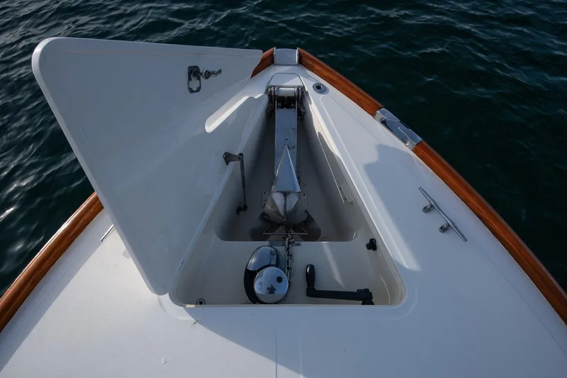 Slide: The Image of 2001 Hinckley Picnic Boat Classic anchor compartment with open hatch, on calm water. - 26