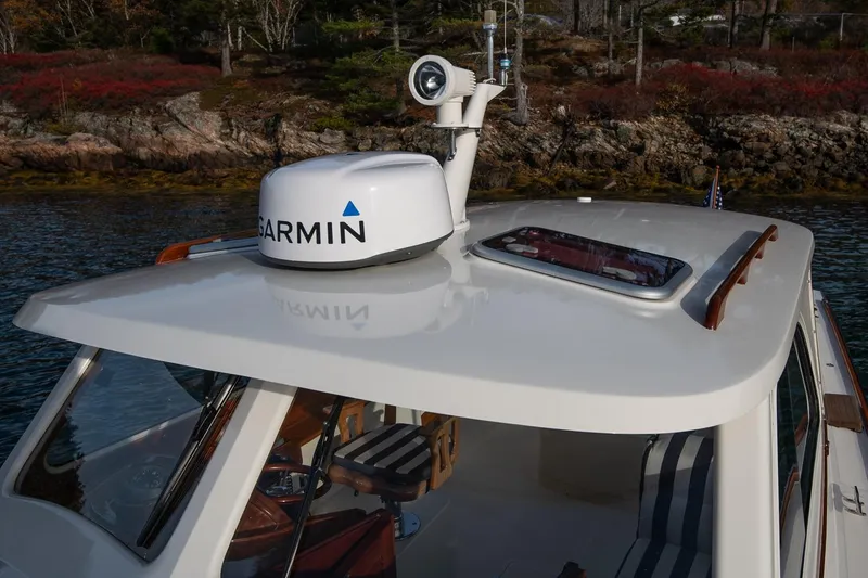 Slide: The Image of 2001 Hinckley Picnic Boat Classic with Garmin radar, docked near rocky shoreline. - 29