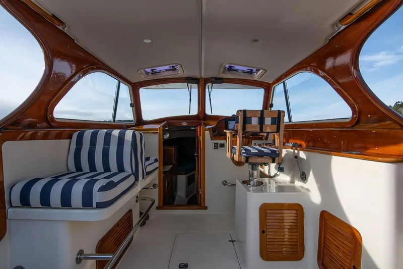 Slide: The Image of Interior of 2001 Hinckley Picnic Boat Classic with striped seating and wooden accents. - 33