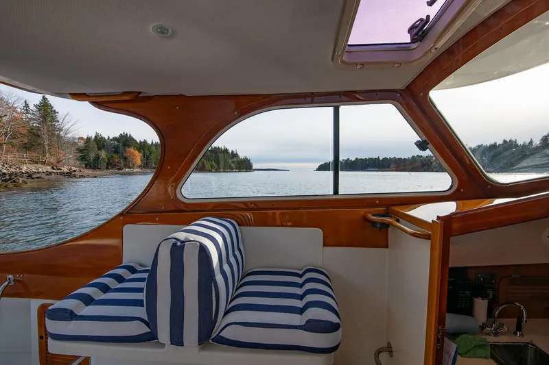 Slide: The Image of Interior view of 2001 Hinckley Picnic Boat Classic with striped seating and scenic waterway. - 39