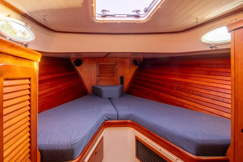 Slide: The Image of 2001 Hinckley Picnic Boat Classic interior with wooden paneling and cozy sleeping area. - 45