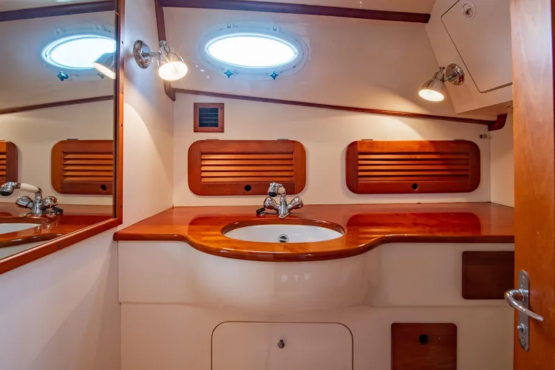 Slide: The Image of 2001 Hinckley Picnic Boat Classic bathroom with wooden accents and round porthole window. - 46