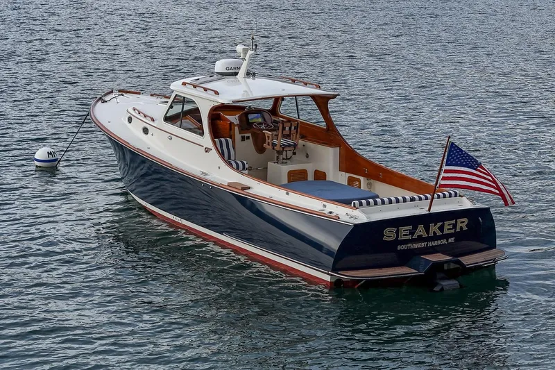 Slide: The Image of 2001 Hinckley Picnic Boat Classic on water, displaying American flag. - 6