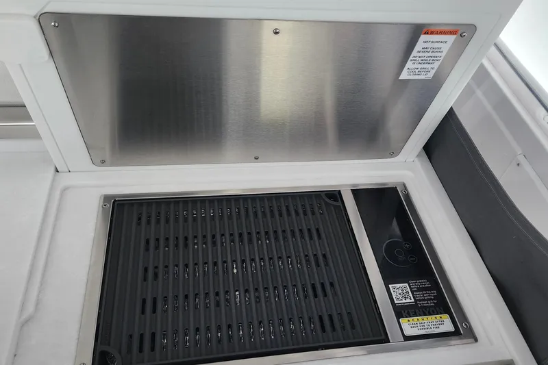 Slide: The Image of Built-in grill on 2026 Tiara Yachts 34 LS, featuring stainless steel cover. - 11