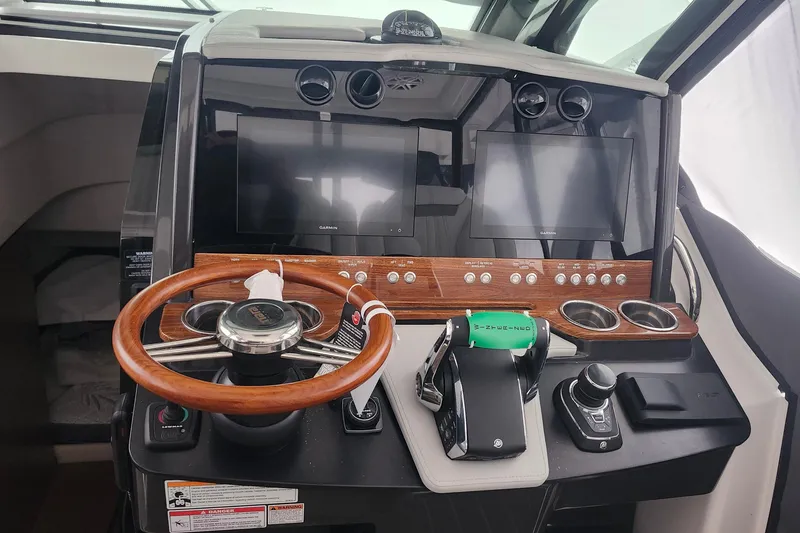 Slide: The Image of 2026 Tiara Yachts 34 LS helm with dual screens and wooden steering wheel. - 17