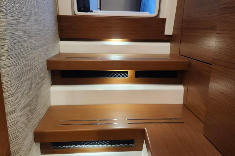 Slide: The Image of 2026 Tiara Yachts 34 LS interior stairs with wood finish and modern lighting. - 24