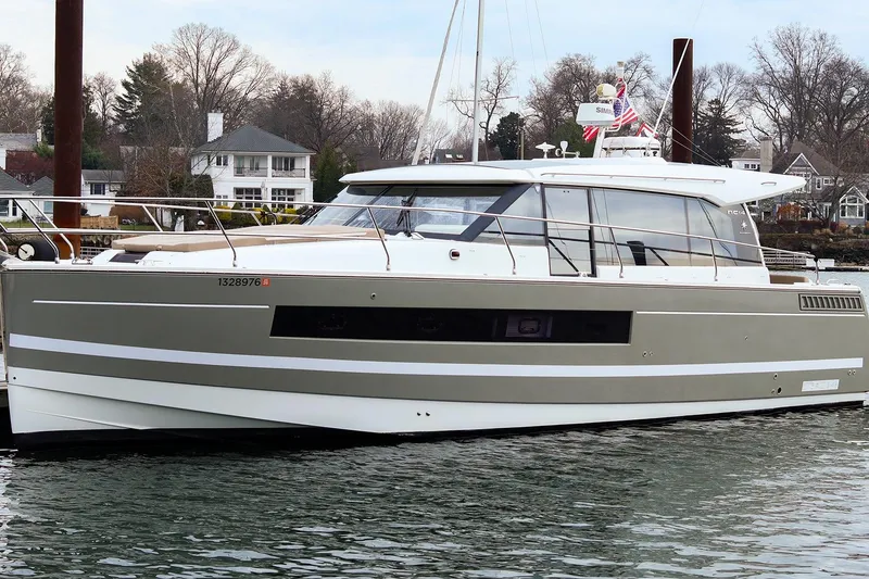 Slide: The Image of 2015 Jeanneau NC 14 yacht docked in a serene waterfront setting. - 0