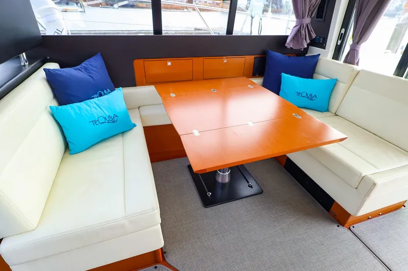 Slide: The Image of Interior of 2015 Jeanneau NC 14 yacht with cozy seating and wooden table. - 10