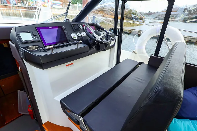 Slide: The Image of 2015 Jeanneau NC 14 helm station with modern navigation equipment and comfortable seating. - 12