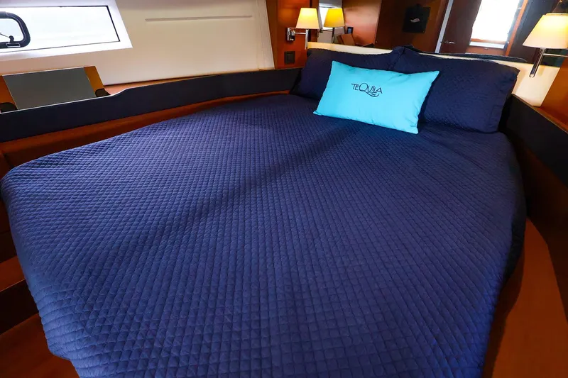 Slide: The Image of Luxurious cabin interior of 2015 Jeanneau NC 14 yacht with blue bedding. - 19
