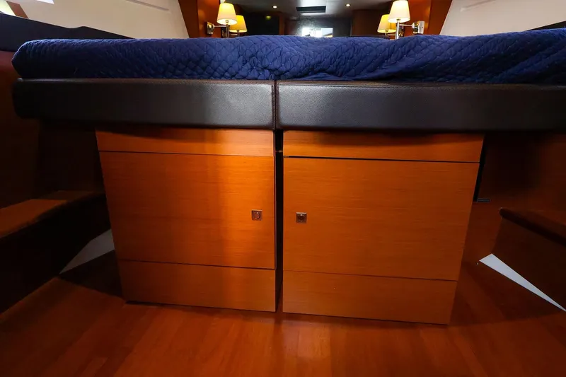 Slide: The Image of Luxurious interior of 2015 Jeanneau NC 14 yacht with wooden cabinetry and blue bedding. - 20