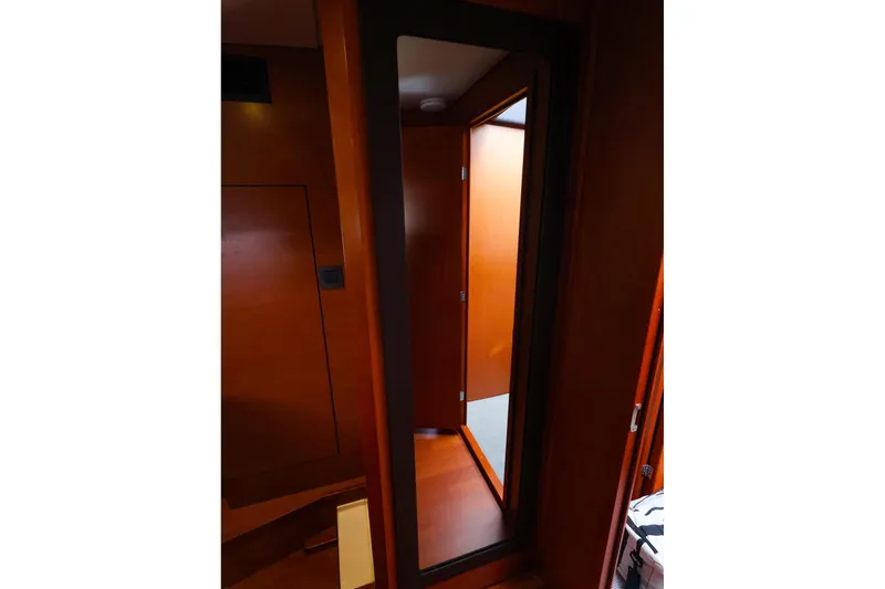 Slide: The Image of Interior view of 2015 Jeanneau NC 14 yacht, featuring wooden paneling and a mirror. - 22