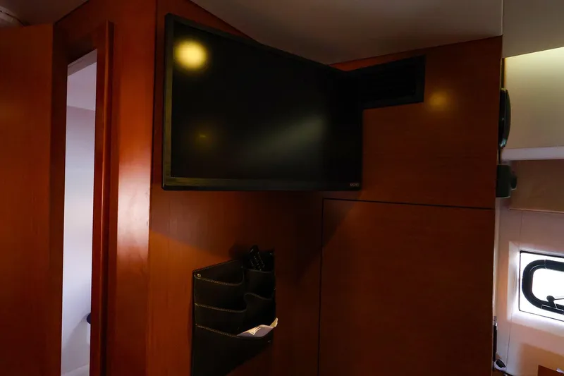 Slide: The Image of Interior of 2015 Jeanneau NC 14 yacht with mounted TV and wooden paneling. - 23