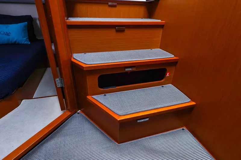 Slide: The Image of Interior stairs of a 2015 Jeanneau NC 14 yacht with carpeted steps. - 24
