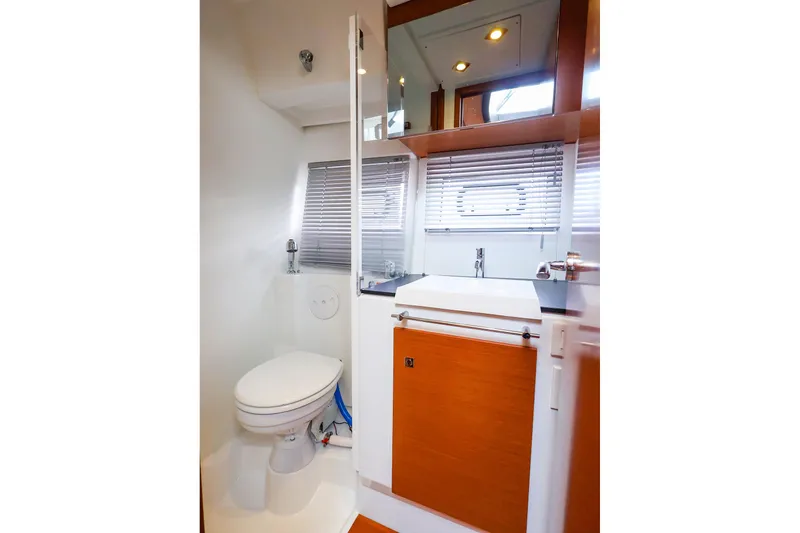 Slide: The Image of 2015 Jeanneau NC 14 yacht bathroom with modern fixtures and wooden cabinetry. - 26