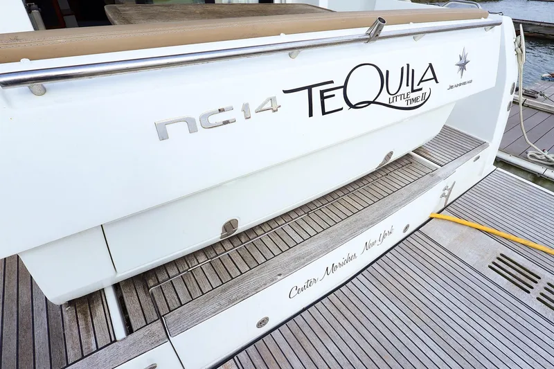 Slide: The Image of 2015 Jeanneau NC 14 yacht stern with "Tequila" name, docked on wooden deck. - 3