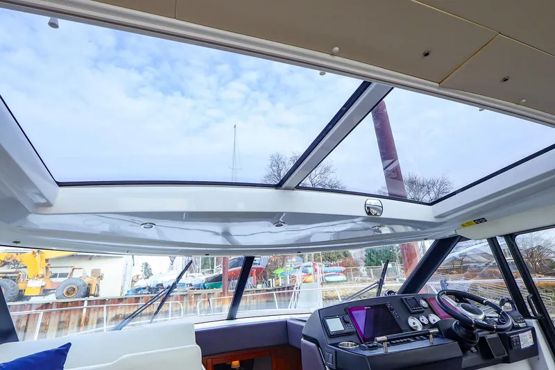 Slide: The Image of Interior view of 2015 Jeanneau NC 14 yacht with panoramic sunroof and modern helm. - 6