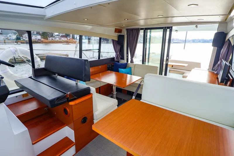Slide: The Image of Interior of 2015 Jeanneau NC 14 yacht with modern seating and large windows. - 8