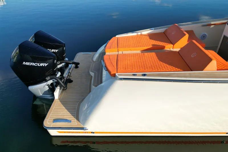 Slide: The Image of 2026 Lilybaeum Lipari 31 boat with Mercury engine on calm water, city skyline in background. - 31