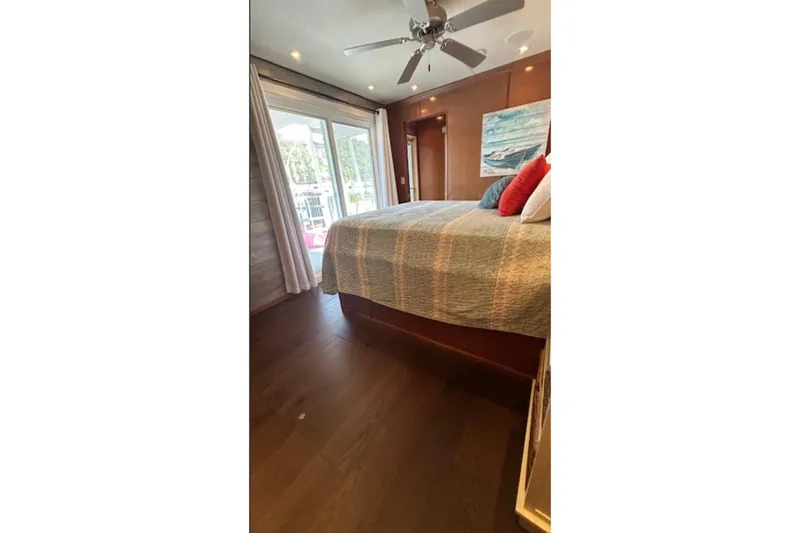Slide: The Image of Cozy bedroom with ceiling fan, large bed, and sliding glass doors on a 2007 Sharpe 18 x 90. - 21