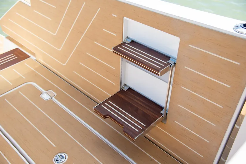 Slide: The Image of 2026 Regal LX43 boat with wooden swim platform and foldable steps. - 21