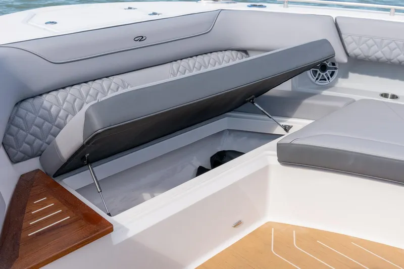 Slide: The Image of 2026 Regal LX43 boat interior with open storage compartment and cushioned seating. - 24