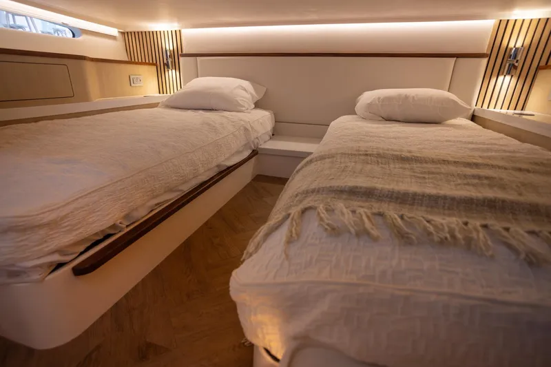 Slide: The Image of Luxurious twin cabin interior of 2026 Regal LX43 yacht, featuring elegant bedding and ambient lighting. - 36