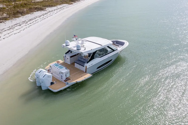 Slide: The Image of 2026 Regal LX43 boat cruising near a sandy shoreline. - 4