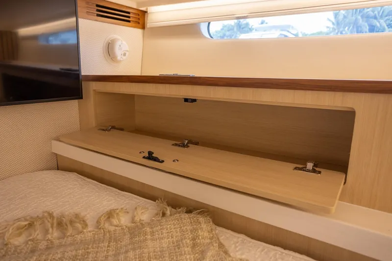 Slide: The Image of Interior of 2026 Regal LX43 yacht with open wooden storage compartment. - 41