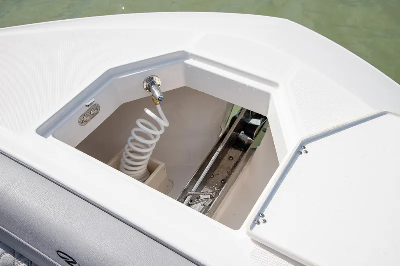 Slide: The Image of Anchor compartment of 2026 Regal LX43 boat with coiled hose and fittings. - 44