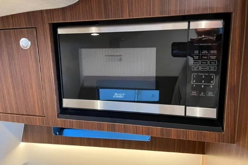 Slide: The Image of Built-in microwave in 2023 Pursuit S 358 Sport boat, wood paneling. - 9