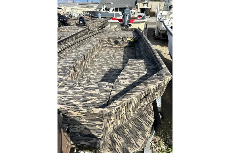 Slide: The Image of 2025 Havoc 1756 MRST boat with camouflage pattern in a marina setting. - 2