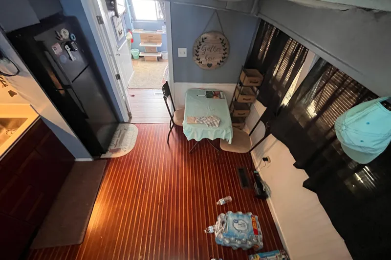 Slide: The Image of Interior of a 1972 Whitcraft houseboat with wooden flooring and a small dining area. - 11
