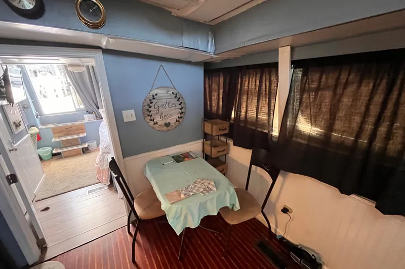 Slide: The Image of 1972 Whitcraft houseboat interior with dining area, cozy decor, and natural light. - 12