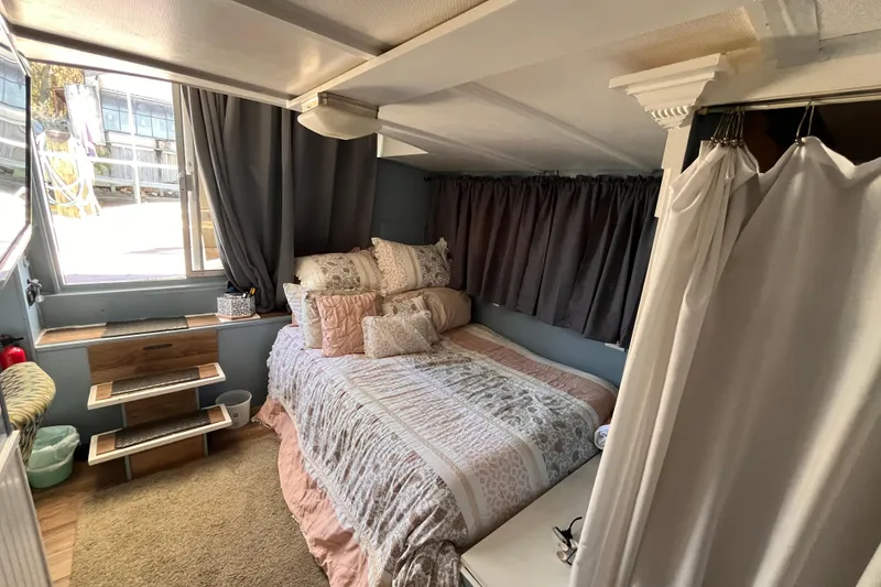 Slide: The Image of Cozy 1972 Whitcraft houseboat interior with bed, curtains, and wooden steps. - 14