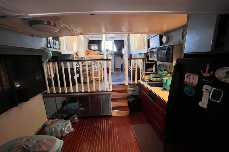 Slide: The Image of Interior of a 1972 Whitcraft houseboat featuring a cozy living area and kitchen. - 16