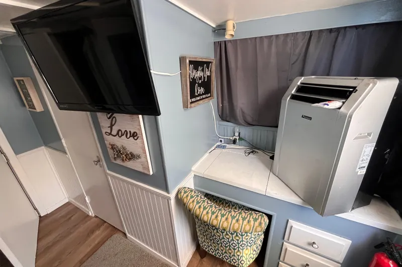 Slide: The Image of Interior of a 1972 Whitcraft houseboat with TV, decor, and air conditioner. - 22