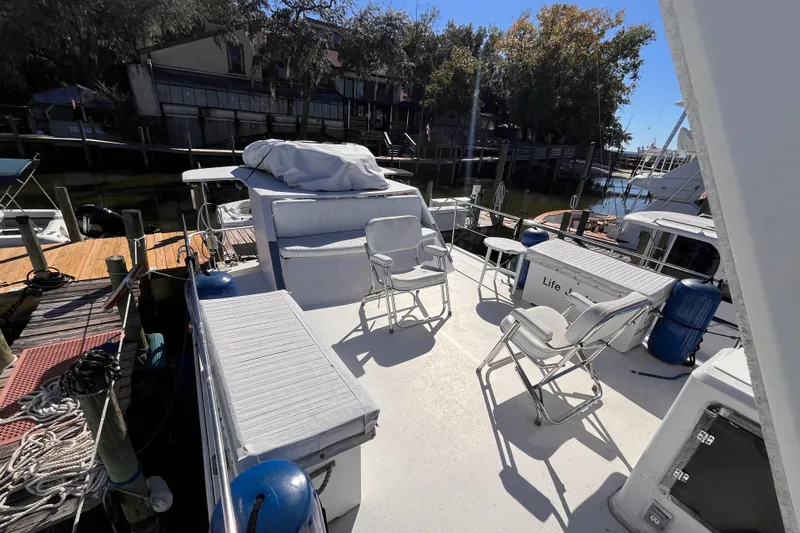 Slide: The Image of 1972 Whitcraft houseboat deck with chairs, docked at a marina under sunny skies. - 27
