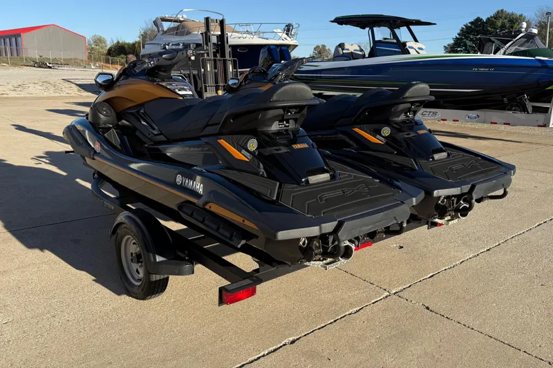 Slide: The Image of 2024 Yamaha WaveRunner FX Limited SVHO jet skis on a trailer, parked outdoors. - 2