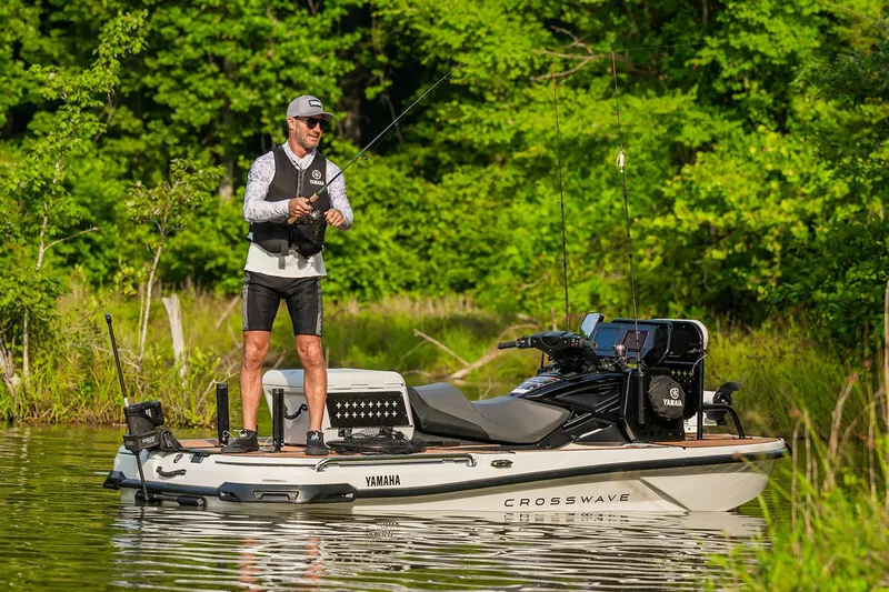Slide: The Image of Manufacturer Provided Image: Man fishing on 2026 Yamaha WaveRunner Crosswave in a lush, green setting. - 2