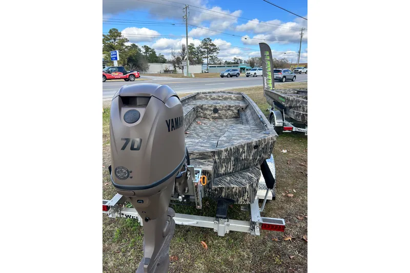 Slide: The Image of 2025 Havoc 1756 MRST boat with Yamaha 70 outboard motor, parked outdoors. - 1