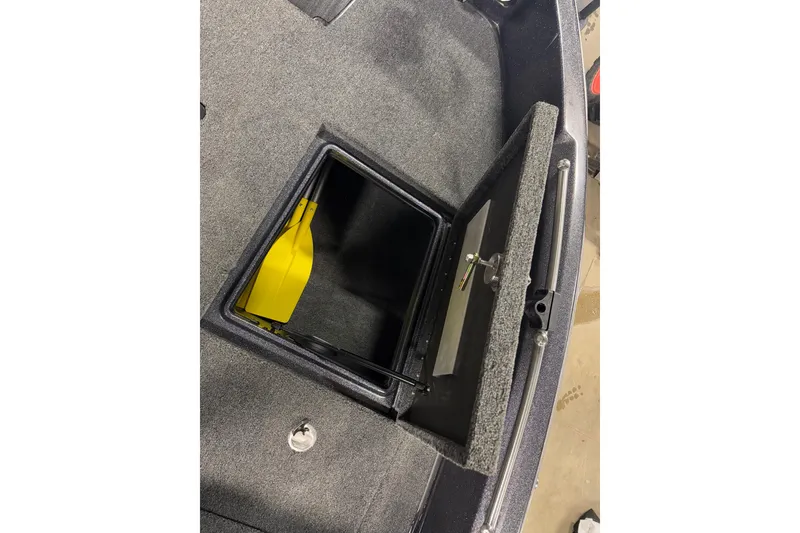 Slide: The Image of Open storage compartment in 2024 Nitro ZV19 Sport boat with yellow paddle inside. - 18