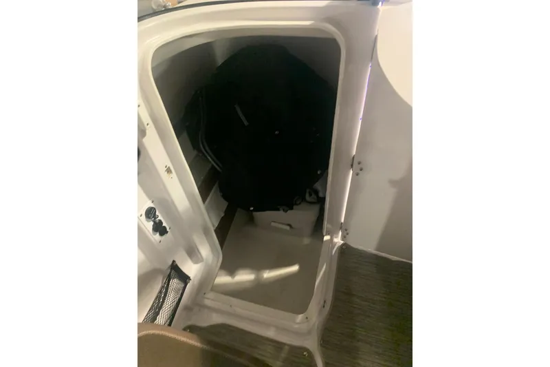Slide: The Image of Storage compartment inside 2019 Scarab 255 Wake ID boat, featuring a black bag. - 19