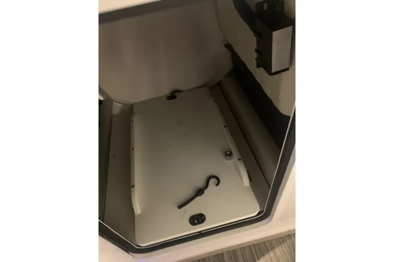 Slide: The Image of Storage compartment of 2019 Scarab 255 Wake ID boat, featuring hooks and a latch. - 23