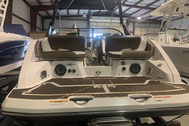 Slide: The Image of 2019 Scarab 255 Wake ID boat interior with seating and speakers in a showroom. - 3