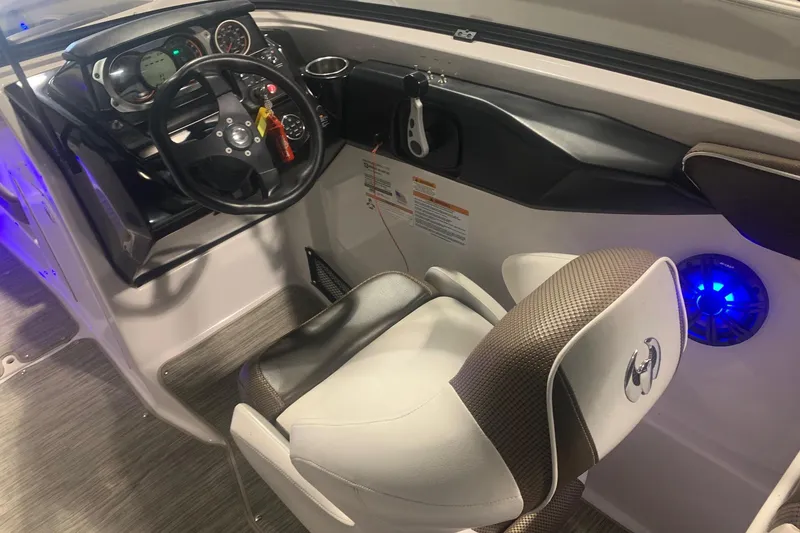 Slide: The Image of 2019 Scarab 255 Wake ID boat cockpit with steering wheel and illuminated controls. - 4