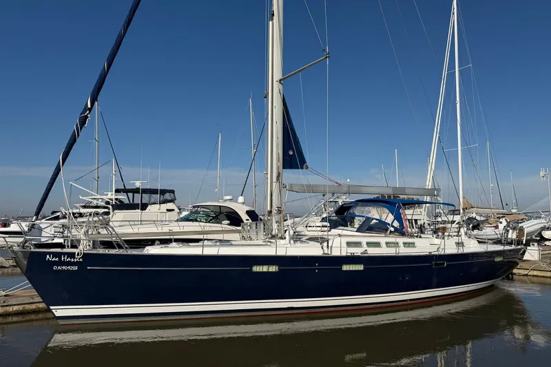 The Image of 2004 Beneteau 57 sailboat docked in marina under clear blue sky. - 0