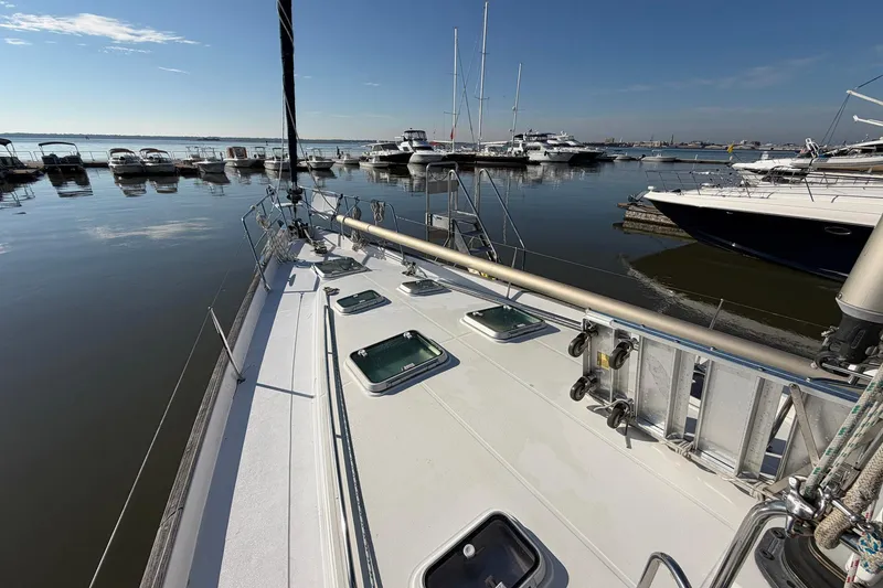 Slide: The Image of 2004 Beneteau 57 sailboat docked in a marina under clear blue skies. - 16