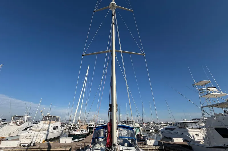 Slide: The Image of Sailboat Beneteau 57, 2004 model, docked in a marina under clear blue skies. - 17